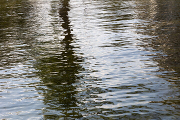 Slowly moving littles waves on water with reflections