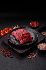 Raw beef tenderloin cut into slices with salt and spices