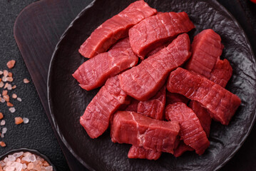 Raw beef tenderloin cut into slices with salt and spices