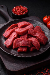 Raw beef tenderloin cut into slices with salt and spices