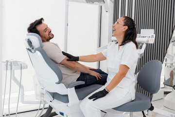 Obraz premium Patient enjoys a lighthearted moment with a dentist during an appointment in a modern clinic