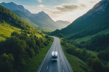 Drone view of scenic mountain highway with modern camper motorhome on sunny summer morning
