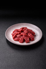 Raw beef tenderloin cut into slices with salt and spices