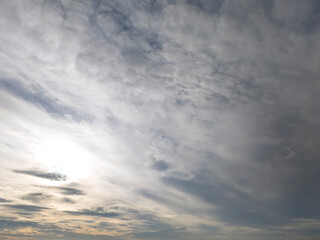 A beautiful cloud-filled sky with the sun peeking through, creating a serene and tranquil atmosphere, perfect for nature lovers and photographers.