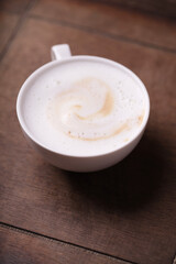 Cappuccino on dark wooden background. Soft focus. Close up.
