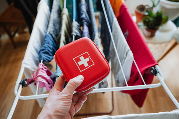 Having a First Aid Kit readily available in hand along with clothes drying on a rack signifies...
