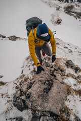 Alpine mountain athlete running and climbing in snow covered winter mountain alpine landscape. Extreme outdoor activities in Hochschwab mountain range, Austria.