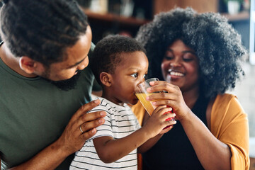 child family kitchen boy son mother father drink breakfast juice healthy fruit food drinking thirsty eating glass home black african american childhood cute love bonding