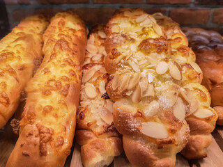 Freshly baked long shaped bread with nuts on shelves in a bakery or cafe. Food or lunch concept.