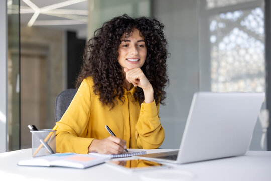 Businesswoman filling out tax forms online. Woman smiling and happy with paperwork inside office, working with contracts, documents and reports. - Powered by Adobe