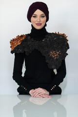 A stylish Muslim woman in a hijab presents her innovative handmade fashion accessory crafted from...