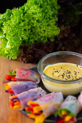 Homemade veggies spring rolls with asiatic sauces over wooden surface