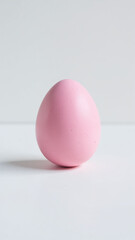 single handmade pink easter egg sits alone pristine white surface precise clipping path around