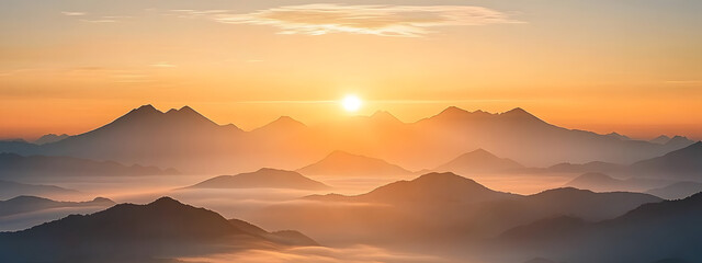 Obraz premium Sunrise over the mountains, with mist rising from below and the sun at the center 