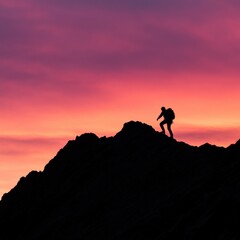 Silhouette of hiker climbing mountain during vivid sunset