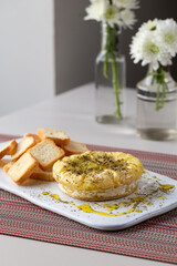 Camembert cheese puff in the oven with olive oil and oregano, Braga, Portugal.