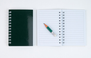 open notebook and pencil displayed on a white surface
