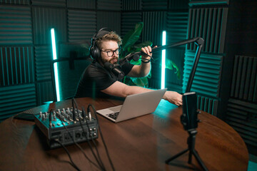 Live streaming with smiling millennial man as radio presenter with microphone, talk show or...