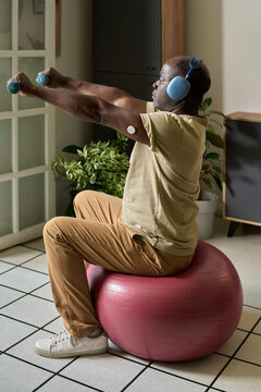 Continuing Exercise Routine with Dumbbells on Yoga Ball