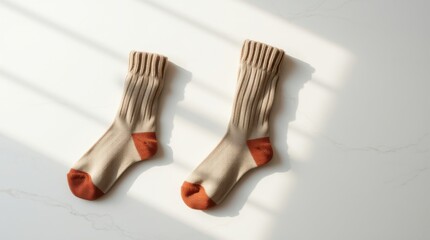 Cozy Pair: Knitted socks with warm hues cast a gentle shadow, evoking comfort and relaxation.