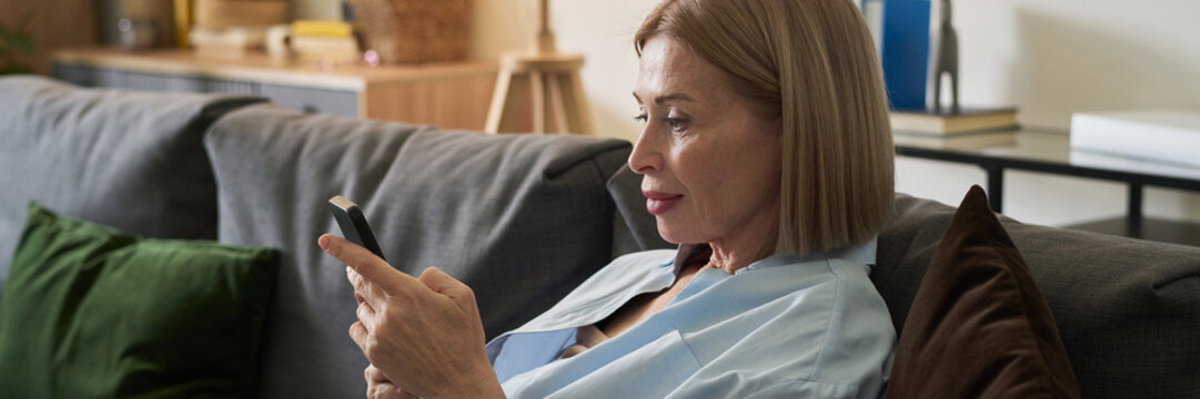 Elderly Woman Using Smartphone While Sitting on Couch