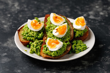Smashed peas and egg sourdough toast with whole grain mustard sauce. Protein packed vegetarian food concept