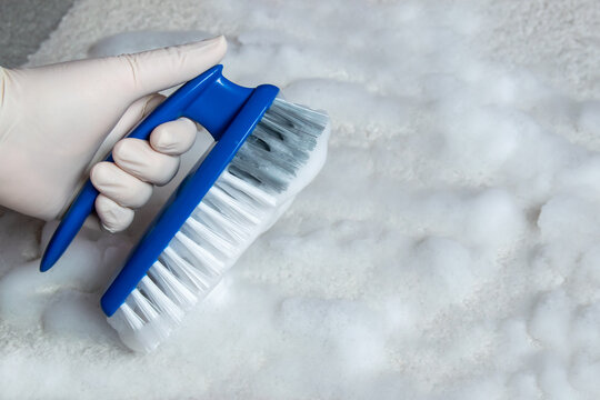 Blue brush on the floor with much white foam. Cleaning.