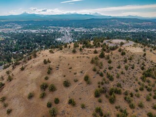 High-angle view of Pilot Butte Neighbourhood Park from a hilltop. City sprawls below, with mountains in the distance. ,Bend, Oregon, USA