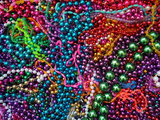 Mardi Gras beads assortment flat lay pile of multicolor parade throws New Orleans street festival necklaces