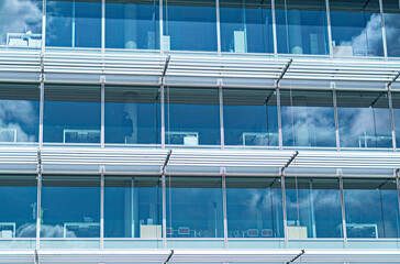 modern office building with windows and the blue sky reflection