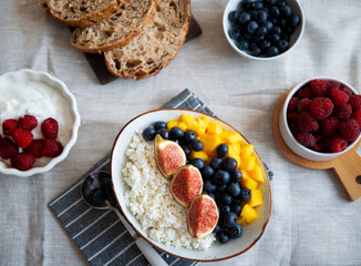 Cottage cheese with berries. Bowl of cottage cheese with mango, blueberry and fig,  healthy breakfast or lunch