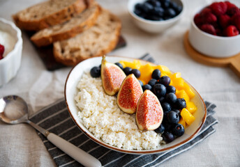 Cottage cheese with berries. Bowl of cottage cheese with mango, blueberry and fig,  healthy breakfast or lunch