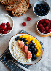 Cottage cheese with berries. Bowl of cottage cheese with mango, blueberry and fig,  healthy breakfast or lunch
