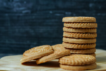 stack of delicious almond biscuits on a wooden board isolated dark background