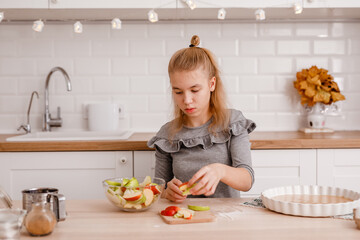 Twelve-year-old girl slicing apple on kitchen counter for autumn pie