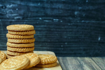 stack of delicious almond biscuits on a wooden board isolated dark background