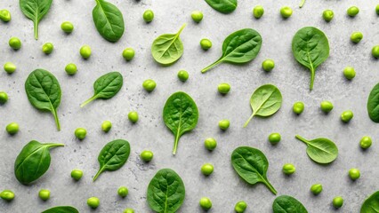 Green peas and spinach leaves arranged in a repetitive pattern on a grey surface.  The image evokes a sense of freshness and healthy eating.