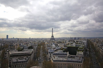Fototapeta premium Evening view of Eiffel Tower panorama City panorama with the Eiffel Tower rising through a moody cloud sky, rooftops and avenues stretching toward the landmark.