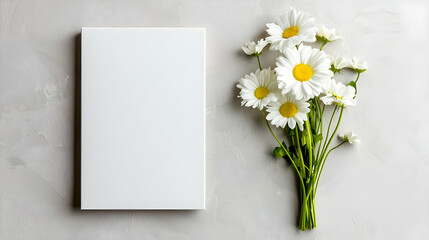 Blank notebook beside daisies on marble.  Perfect for greeting cards