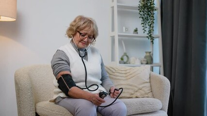 Woman pensioner measuring blood pressure with tonometer, stroke prevention or heart attack