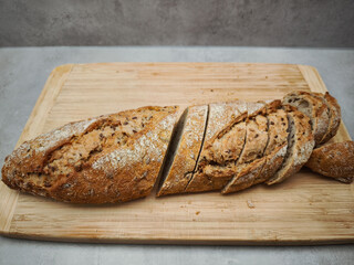 Sliced multigrain bread loaf on wooden cutting board