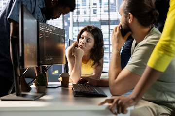 IT staff members gathered together to conduct code review to fix bugs, identifying technical issues with artificial intelligence company software. Team coworkers doing brainstorming, optimizing code