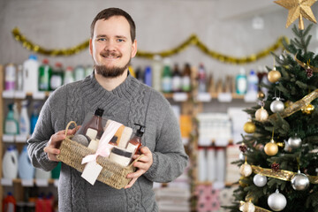 On Christmas Eve, man gets acquainted with assortment, choose shower cosmetics present set. Client...