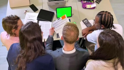 Business team analyzing reports with green screen tablet