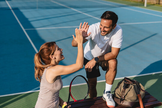 Young couple playing tennis outdoors enjoying a fun summer game