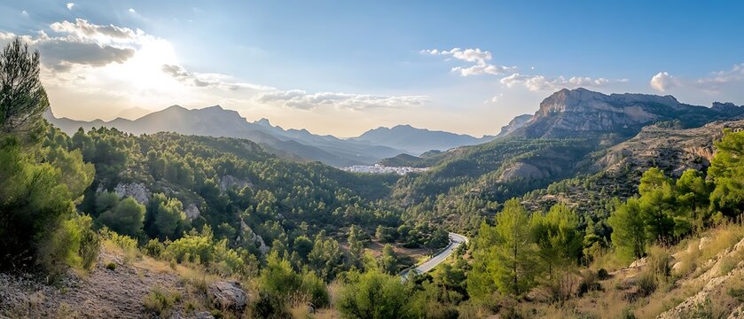 Scenic view of majestic mountains surrounded by lush green trees under a clear blue sky.