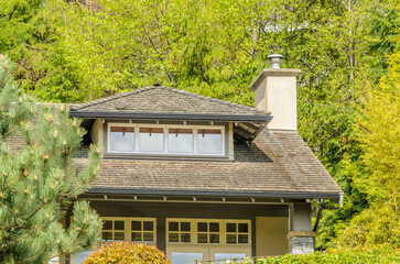 Top of luxury house with shingle roof, red and yellow trees and nice windows in Summer in...