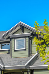 Top of luxury house with shingle roof, red and yellow trees and nice windows in Summer in Vancouver, Canada, North America. Day time on June 2024.