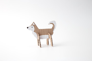 Handmade cardboard husky figurine painted in white and brown. DIY sled dog craft made from recycled materials. Creative winter craft project for kids. step in creative process,