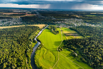 Drone view of scenic countryside with rain clouds in the distance, rains coming